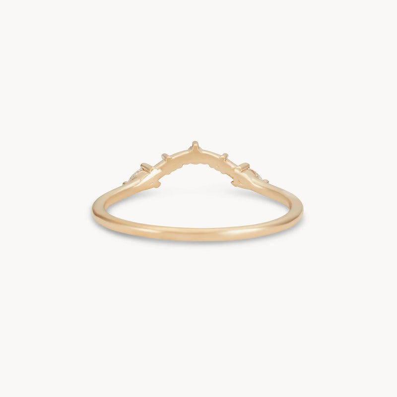 Introducing the "A deep love band" by beloved by bluboho, a delicate 14k yellow gold ring with a slender band and an elegant V-shaped design in the center. The ring features subtle, raised decorative elements along the curve of the V and is adorned with white diamonds, all beautifully showcased against a white background.