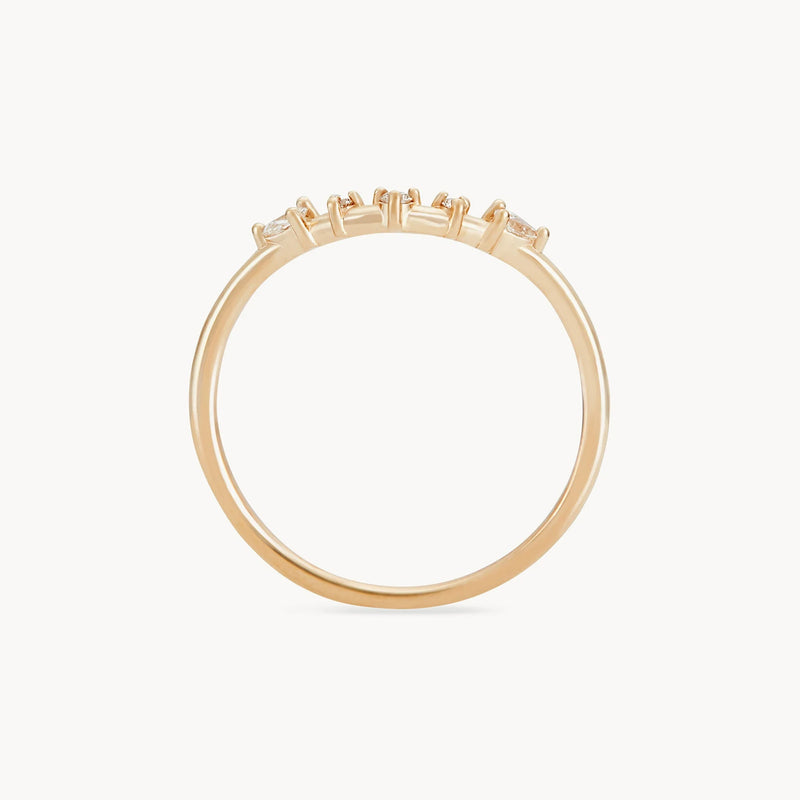 A close-up image of a delicate, thin band named 'A deep love band' made from 14k yellow gold by beloved by bluboho, featuring small, spaced white diamonds set along the top. The design of the ring is simple and elegant, showcasing the gemstones prominently against a plain white background.