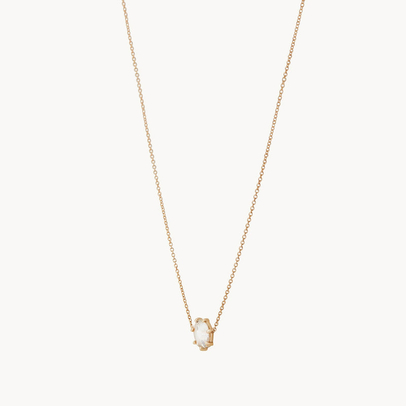 Introducing the extra large supernova necklace by bluboho. This refined piece boasts a delicate 14k yellow gold chain elegantly accentuating a small, oval-shaped white stone pendant. Its minimalist and sophisticated setting is perfectly highlighted against a plain white background.