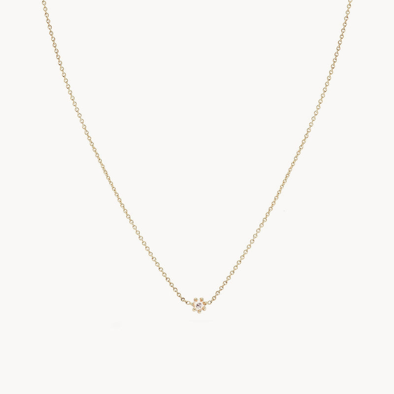 The Dainty Diamond Nova Necklace by bluboho features a delicate 14k yellow gold chain with a small, central flower-shaped pendant. The pendant's simple and elegant design makes this necklace a subtle yet beautiful accessory. The image background is plain white.