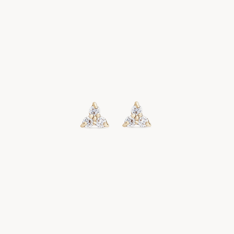 A pair of abacus tripod diamond earrings by bluboho showcases a sleek triangular design with three glistening white diamonds set in 14k yellow gold. The diamonds are meticulously arranged in a pointed triangle pattern, each secured by gold prongs. Set against a plain white background, these earrings truly stand out.