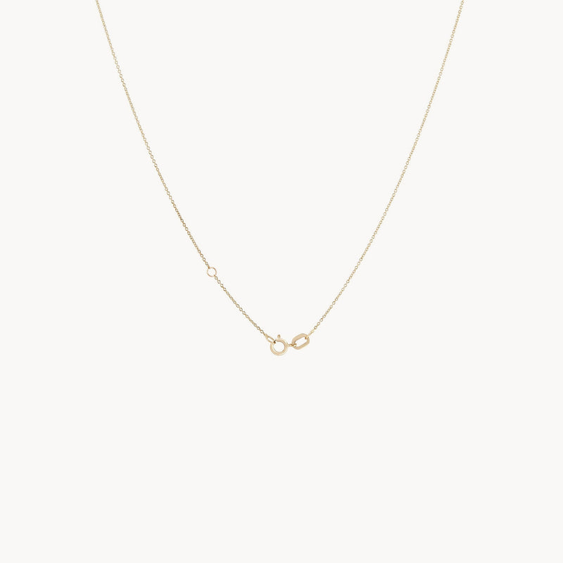 A delicate 14k yellow gold chain necklace by bluboho, called "Lean on me diamond necklace," showcases a subtle side clasp. Its thin and elegant design adds a touch of minimalistic sophistication against the plain white background, accentuating its simplicity.