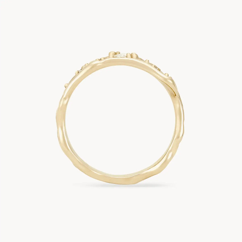 Presenting the Luminous Honey Diamond Ring by bluboho, a minimalist 14k yellow gold ring with an organically textured band, adorned with small white diamond bead-like details along the top edge, showcased against a plain white background.