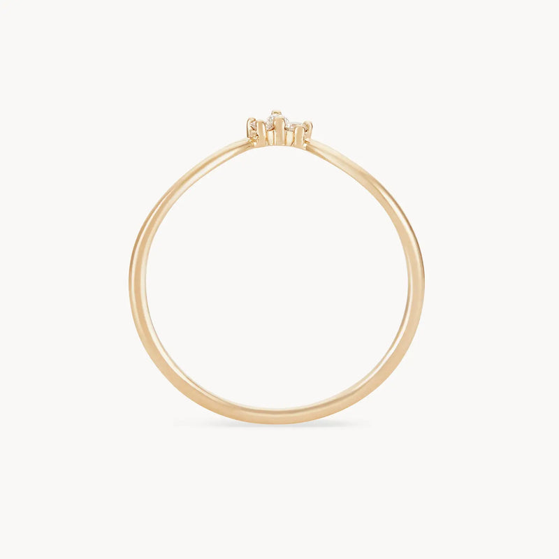 The Mini Moonbow Ring in 14k yellow gold from bluboho is displayed with a small diamond solitaire in a raised prong setting against a plain white background.