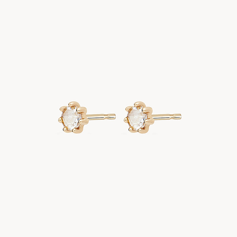 A pair of bluboho nova earrings - 14k yellow gold, white diamond with small, clear, marquise-cut gemstones set in a gold-tone metal. The earrings have a simple and elegant design, ideal for everyday wear. The background is a plain, light color that highlights the earrings.