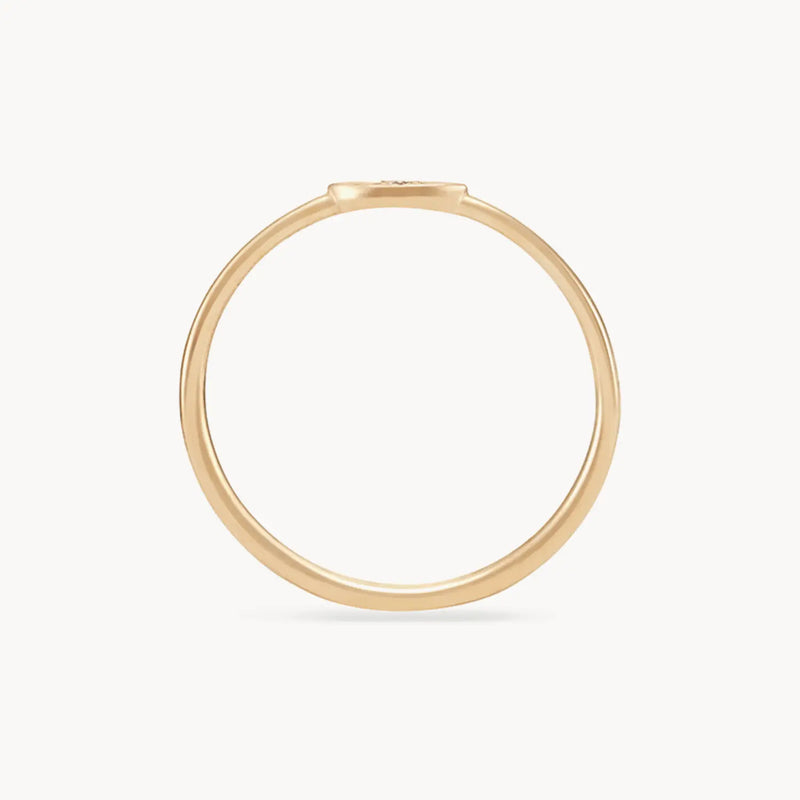 A simple and elegant visionary evil eye ring crafted from 14k yellow gold, featuring a brilliant diamond with a thin band is viewed from the side. The image shows the bluboho ring on a plain white background, highlighting its minimalistic design.
